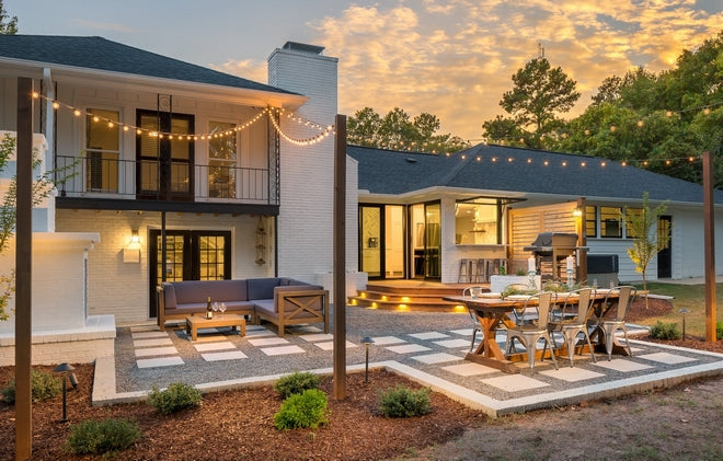 Renovated backyard with modern paver patio, outdoor dining table, lounge seating, and string lights creating an inviting outdoor living space in Sun Prairie, WI.