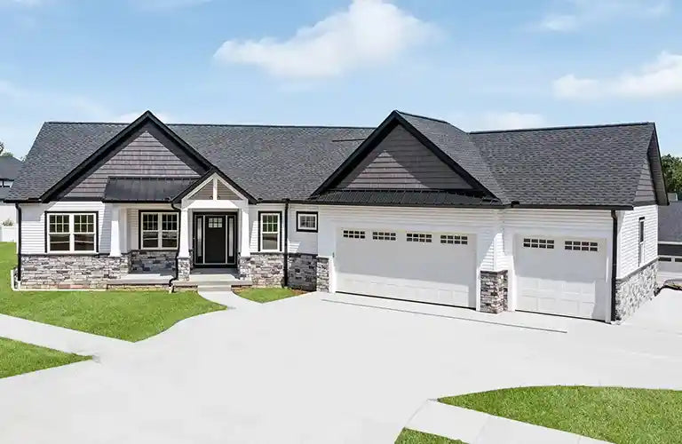 Single-story custom ranch home with white siding, stone accents, dark gables, and a three-car garage on a landscaped lot in Sun Prairie, WI.